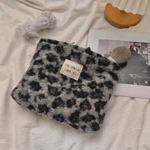 Close-up of leopard print plush makeup bag with embroidery detail on soft fleece fabric