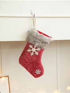 Close-up of red Christmas stocking with grey faux fur cuff and white snowflake appliqué
