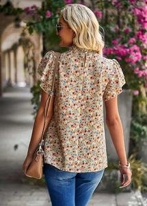 Detailed back view of a floral chiffon blouse with ruffled sleeves and button closure