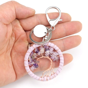 Handmade Tree of Life keychain with amethyst stones and pink suede wrap shown in hand