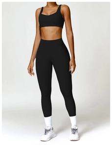 Détail d'un ensemble de yoga noir taille haute avec brassière sport et legging sans couture