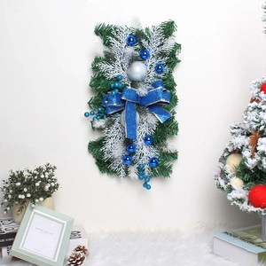 Close-up of a festive Christmas door teardrop wreath with blue ornaments and silver bow