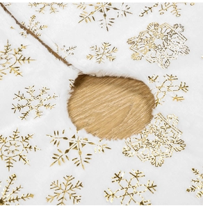 Close-up detail of white faux fur Christmas tree skirt with golden snowflake patterns