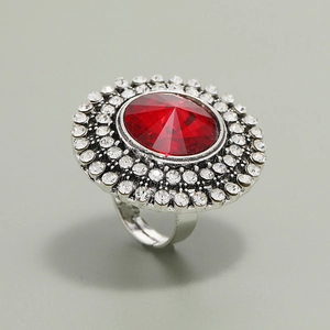 Macro detail of vintage adjustable ring with a large red stone and double rhinestone halo