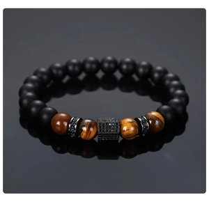 Detailed shot of matte black beads and tiger eye stones with micro-pave hex charm