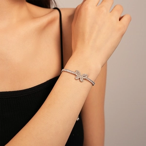 Vista ravvicinata di un bracciale a farfalla in argento con zirconi su un polso femminile
