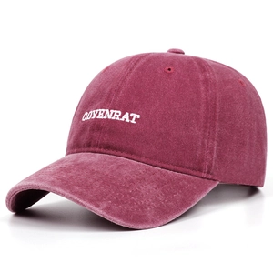 Close-up of COYENRAT embroidery on washed cotton burgundy baseball cap with retro texture