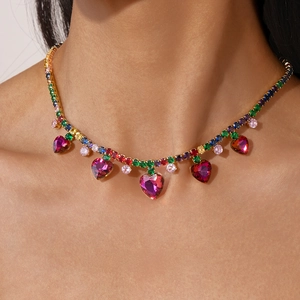 Close-up of rainbow tennis necklace featuring sparkling pink heart crystal pendants
