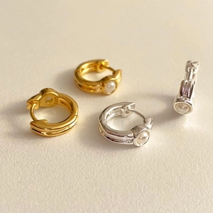 Close-up of S925 sterling silver pearl hoop earrings in gold and silver finishes
