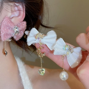 Close-up of fabric bow earrings and hair clips with pearls and crystal pendants