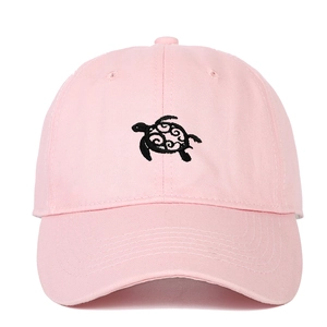 Detailed embroidery of a black sea turtle on pink cotton twill baseball cap fabric