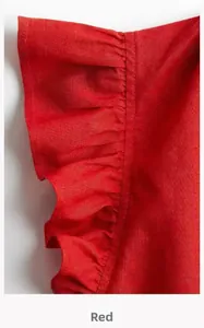 Macro view of ruffled hem detail on a vibrant red linen blend fabric with neat stitching