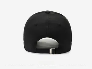 Detail view of the black baseball cap's adjustable silver metal buckle on cotton fabric