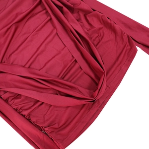 Macro shot of burgundy off-shoulder dress fabric showing pleated texture and fine stitching