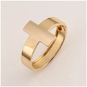 Detailed view of wide golden cross bangle with a high-polished mirror finish and hinge