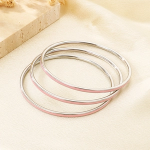 Detail of 3mm stainless steel stackable bangles with silver finish and pink enamel inlay
