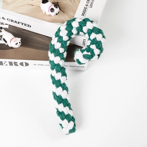 Detail of green and white cotton rope candy cane dog chew toy on white background