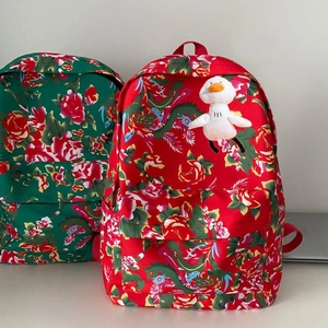 Detail of traditional floral canvas backpacks with plush duck charms and zip closures