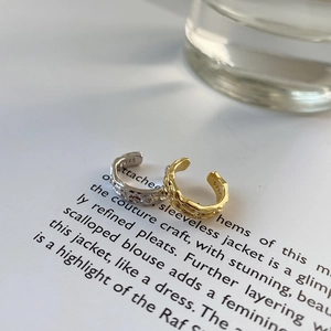 Detail of S925 sterling silver ear cuffs with irregular hammered texture in gold and silver