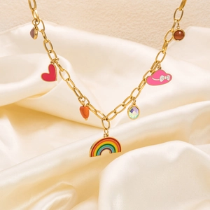 Golden butterfly and rainbow pendant necklace on white silk background with colorful charms