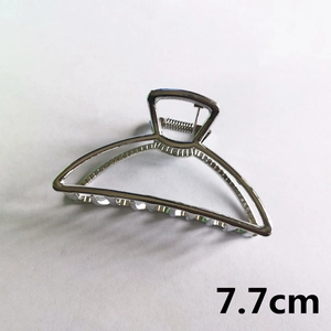 Detail view of 7.7cm silver metal hair claw clip with a hollow semi-circular design