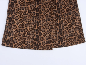 Close-up of classic leopard print on brown suede fabric hem with detailed stitching