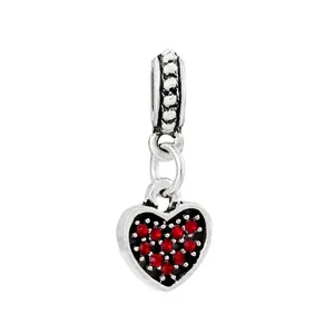 Macro shot of silver heart charm with pavé-set red crystals and circular ring clasp