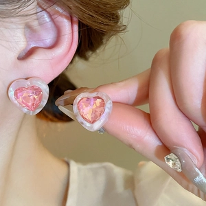 Detailed close-up of pink heart-shaped crystal studs with acrylic frame for women