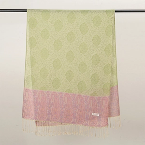 Dettaglio di scialle pashmina verde chiaro con motivo paisley, bordo rosa e frange eleganti