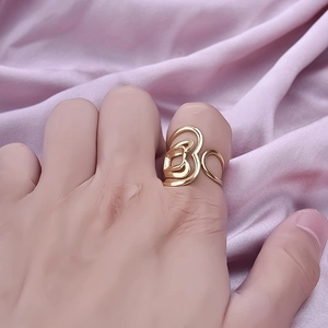 Bague cœur évidée irrégulière en acier inoxydable doré portée sur velours rose