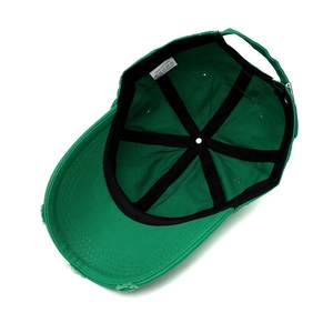 Internal view of green distressed cotton baseball cap showing lining and care label