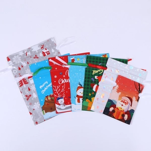 Detailed flat lay of Christmas drawstring gift bags with Santa and reindeer motifs