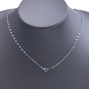 Detailed view of colorful metallic necklace with lobster clasp on a black display stand