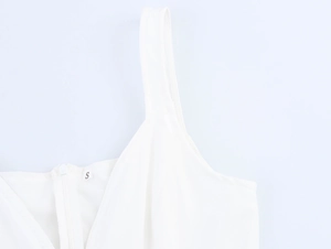 Dettaglio della cerniera invisibile e dell'etichetta S sull'elegante abito bianco a X