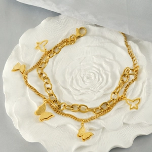 Detail of 18k gold plated double-layer butterfly bracelet on white floral tray