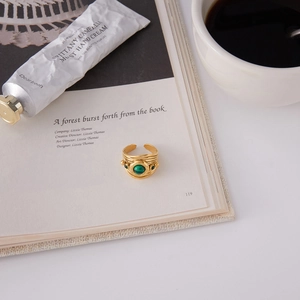 Vintage 18K gold stainless steel ring with green malachite on an open book