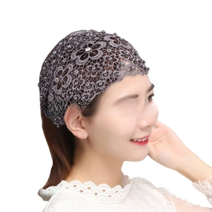 Detail view of gray floral lace headband with elegant pearls and sparkling rhinestones
