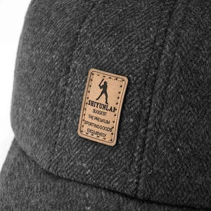 Detail of grey winter baseball cap showing thick wool texture and brown leather patch