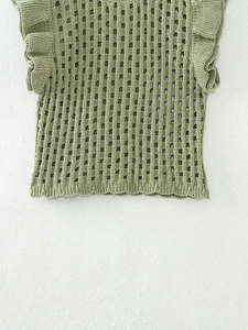 Détail du haut en tricot ajouré vert avec volants et texture douce en chenille
