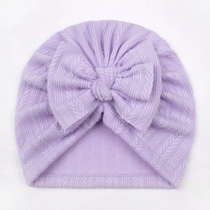 Detail of lavender baby turban featuring a large bow and soft herringbone knit texture