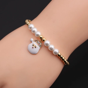 Detail of Christmas beaded bracelet with Santa Claus charm on wrist over black backdrop