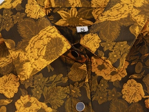 Close-up of vintage collar with golden floral jacquard fabric and size S label