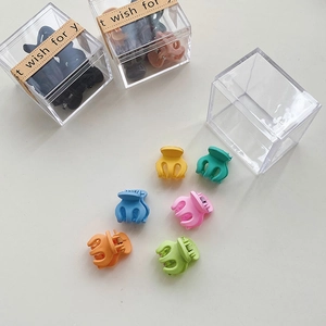 Gros plan de mini pinces à cheveux colorées dans des boîtes en acrylique transparent