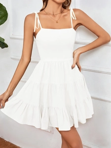 Detail view of white tiered sleeveless mini dress with thin spaghetti straps and square neckline