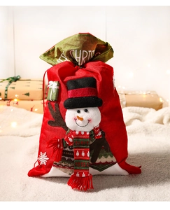 Close-up of a festive red Christmas gift bag with a snowman and soft holiday background