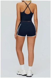 Détail de l'ensemble de yoga bleu marine avec brassière croisée et short bordé de blanc