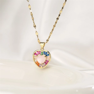 Detail shot of golden heart pendant featuring pink center stone and colorful crystals