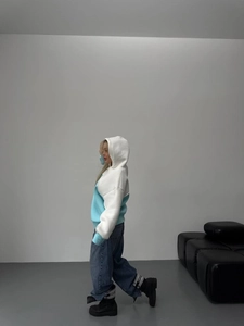 Detail of color-block hooded sweatshirt styled with baggy jeans and black platform boots