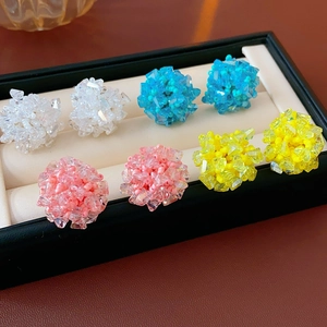 Close-up of beaded flower cluster earrings in white blue pink and yellow colors
