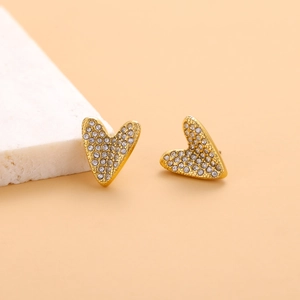Detailed close-up of heart-shaped gold studs featuring shimmering pavé set cubic zirconia